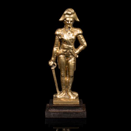 fig 1. A late Georgian brass figural doorstop depicting Admiral Lord Nelson standing in military attire upon a dark stepped base.