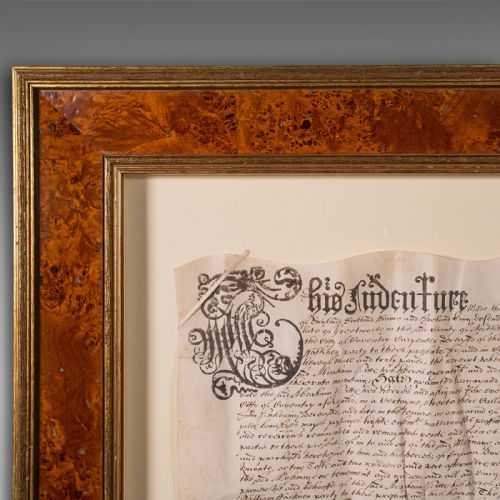 fig 2. A seventeenth-century handwritten vellum indenture with a wax seal, presented inside a light mount and a wide burr wood style frame.
