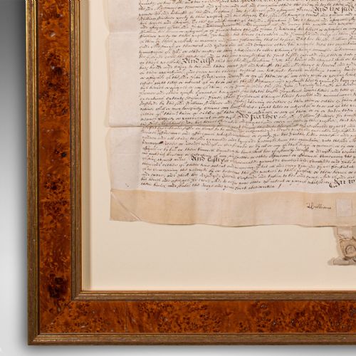 fig 5. A seventeenth-century handwritten vellum indenture with a wax seal, presented inside a light mount and a wide burr wood style frame.