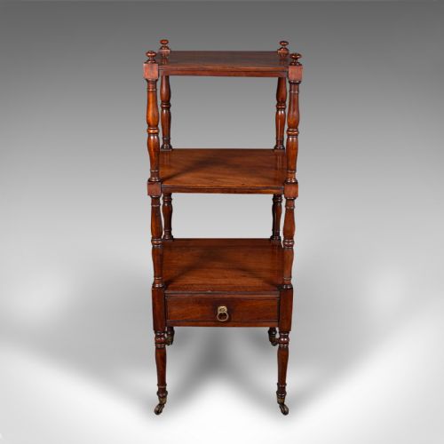 fig 1. A three-tier Late Georgian mahogany whatnot featuring turned upright supports, finials, a lower drawer with a brass ring handle, and brass castors.