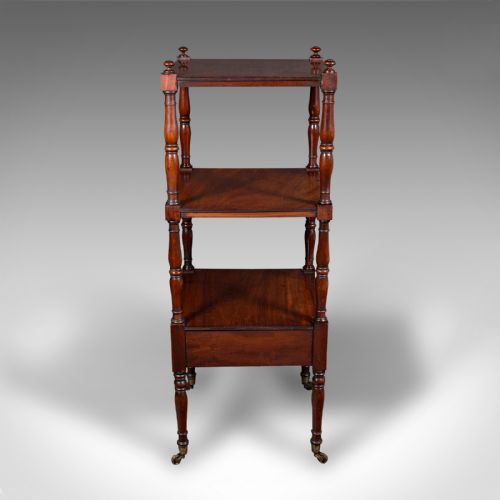 fig 2. A three-tier Late Georgian mahogany whatnot featuring turned upright supports, finials, a lower drawer with a brass ring handle, and brass castors.