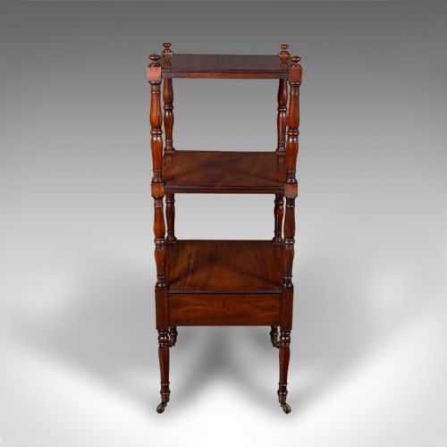 fig 3. A three-tier Late Georgian mahogany whatnot featuring turned upright supports, finials, a lower drawer with a brass ring handle, and brass castors.