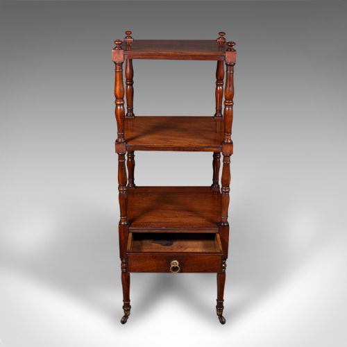 fig 4. A three-tier Late Georgian mahogany whatnot featuring turned upright supports, finials, a lower drawer with a brass ring handle, and brass castors.