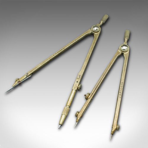 fig 4. An open mahogany wood box with a purple velvet lining containing an array of antique brass drafting compasses and ruling pens.