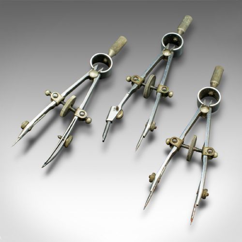 fig 5. An open mahogany wood box with a purple velvet lining containing an array of antique brass drafting compasses and ruling pens.