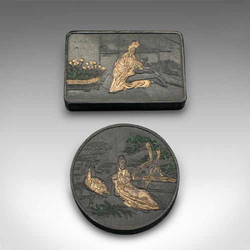 fig 4. An open brown fabric-lined case containing eight black ink blocks of varied geometric shapes decorated with gilded figurative engravings.