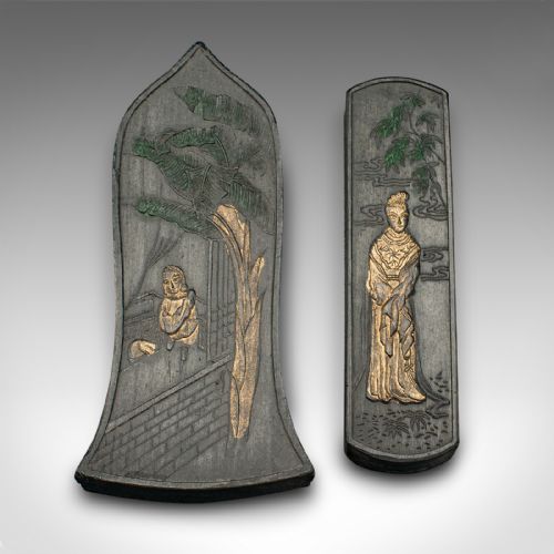 fig 5. An open brown fabric-lined case containing eight black ink blocks of varied geometric shapes decorated with gilded figurative engravings.