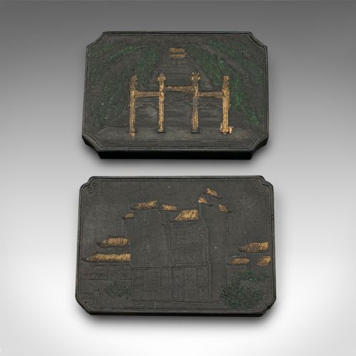 fig 4. An open fabric-lined box displaying a set of eight black Chinese ink blocks adorned with gold and green moulded architectural and figural motifs.