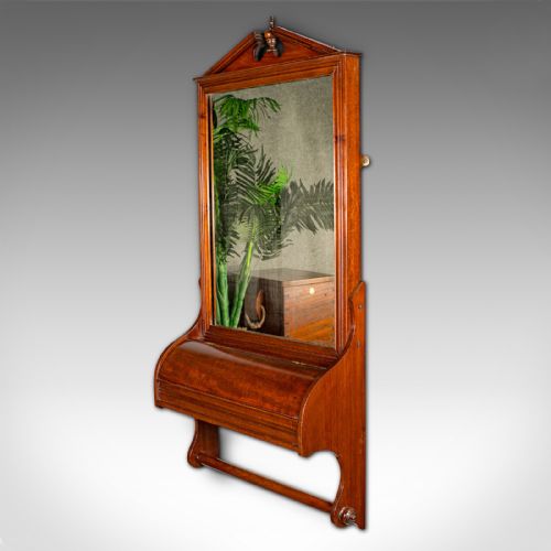 fig 3. A Victorian mahogany wall-mounted valet mirror featuring a pediment top, rectangular glass plate, cylinder glove box, and lower hanging rail.
