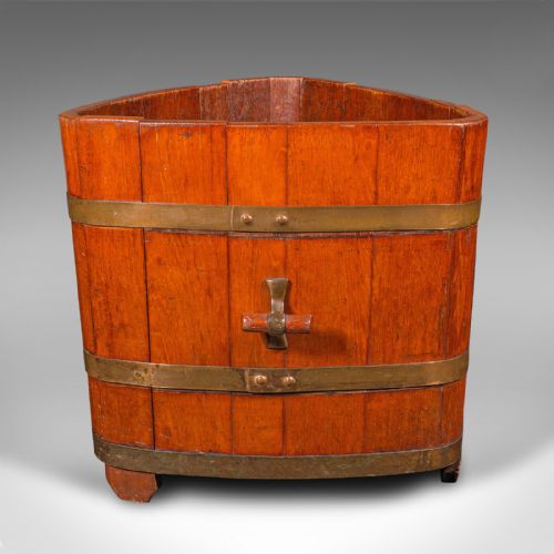 fig 4. An Early Victorian triangular wooden fireside bin constructed with staves bound by brass bands and side carrying handles.