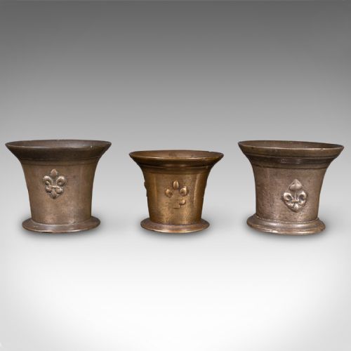 fig 1. A set of three English antique cast bronze apothecary mortars featuring flared rims, circular bases, and raised fleur-de-lis motifs.