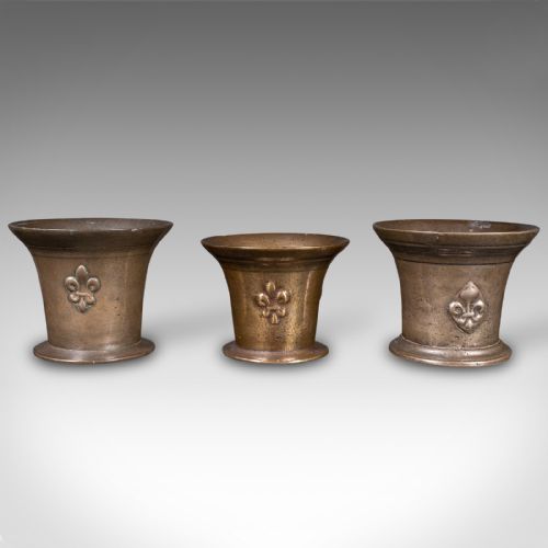 fig 2. A set of three English antique cast bronze apothecary mortars featuring flared rims, circular bases, and raised fleur-de-lis motifs.
