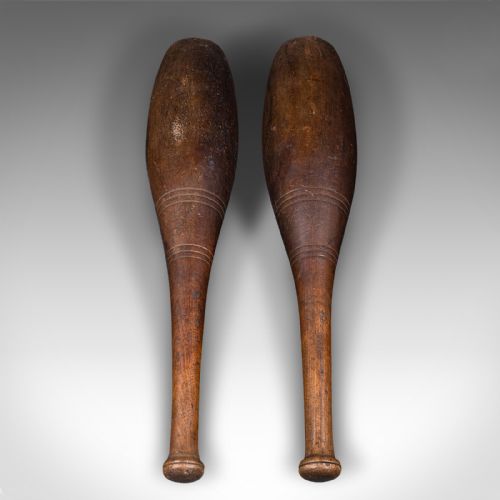 fig 2. A pair of turned brown beech wood Indian exercise clubs featuring incised decorative ring grooves on the handles.