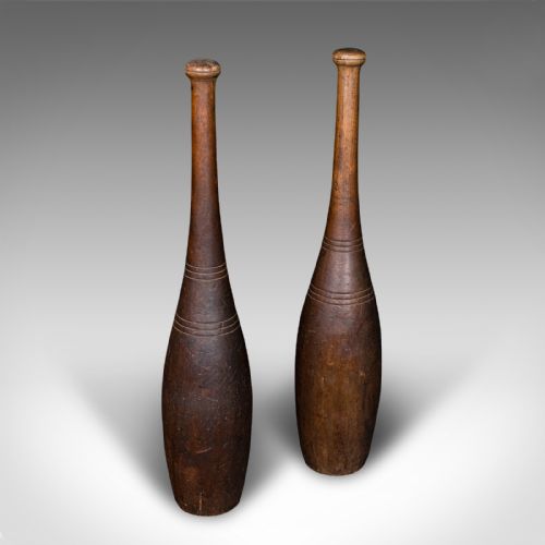 fig 3. A pair of turned brown beech wood Indian exercise clubs featuring incised decorative ring grooves on the handles.
