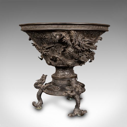 fig 1. A dark patinated Japanese bronze incense censer bowl featuring relief dragon carvings around the body and dragon-shaped tripod feet.