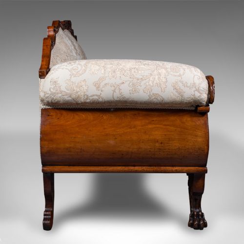 fig 2. A William IV carved mahogany settee featuring cream patterned damask upholstery, scroll arms, bolster cushions, and detailed paw feet.