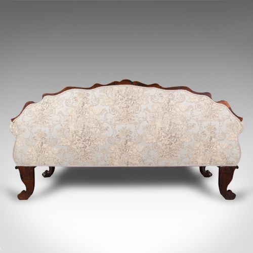 fig 4. A William IV carved mahogany settee featuring cream patterned damask upholstery, scroll arms, bolster cushions, and detailed paw feet.