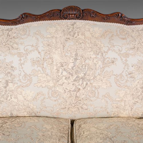 fig 6. A William IV carved mahogany settee featuring cream patterned damask upholstery, scroll arms, bolster cushions, and detailed paw feet.