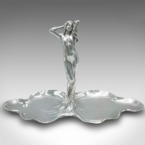 fig 1. A silver-toned Art Nouveau metal card tray featuring a central sculpted maiden figure with flowing hair standing atop a shaped lily pad base.