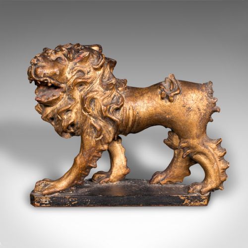 fig 1. A carved Mid-Georgian giltwood lion figure standing on a dark rectangular base with a detailed mane and open mouth.
