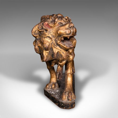 fig 2. A carved Mid-Georgian giltwood lion figure standing on a dark rectangular base with a detailed mane and open mouth.