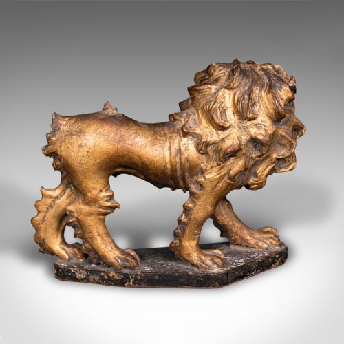 fig 4. A carved Mid-Georgian giltwood lion figure standing on a dark rectangular base with a detailed mane and open mouth.