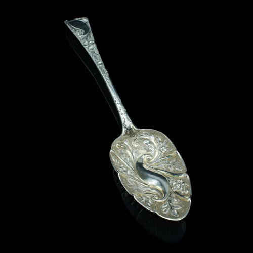 fig 3. A pair of antique Georgian hallmarked sterling silver dessert spoons with ornate repousse foliage decoration in the bowls and stems.