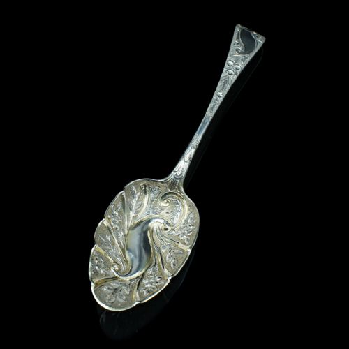 fig 5. A pair of antique Georgian hallmarked sterling silver dessert spoons with ornate repousse foliage decoration in the bowls and stems.
