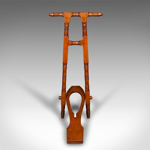 fig 1. A Victorian walnut standing boot jack featuring turned upright supports, a top handlebar, and a folding foot-operated boot pull mechanism.