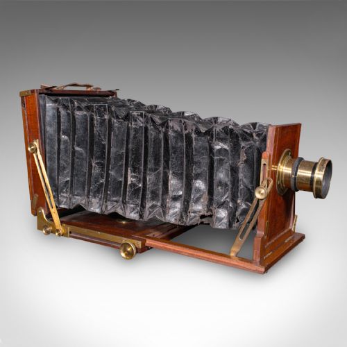 fig 1. A Victorian mahogany and brass field camera mounted on a wooden tripod with wooden plate holders.