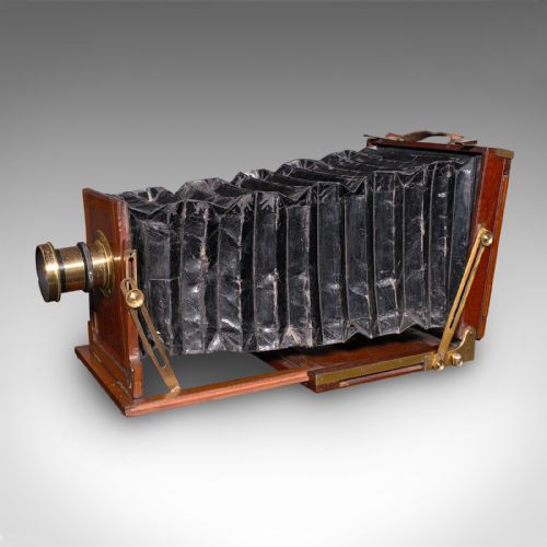 fig 2. A Victorian mahogany and brass field camera mounted on a wooden tripod with wooden plate holders.