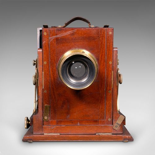 fig 3. A Victorian mahogany and brass field camera mounted on a wooden tripod with wooden plate holders.
