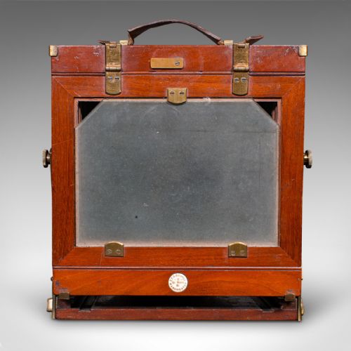 fig 4. A Victorian mahogany and brass field camera mounted on a wooden tripod with wooden plate holders.