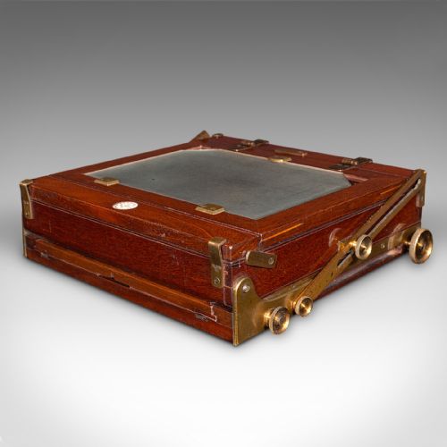 fig 5. A Victorian mahogany and brass field camera mounted on a wooden tripod with wooden plate holders.