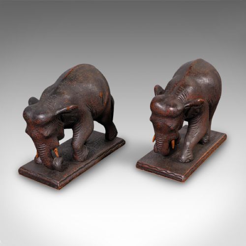 fig 1. A pair of hand-carved dark hardwood bookends shaped like elephants standing on rectangular wooden bases.