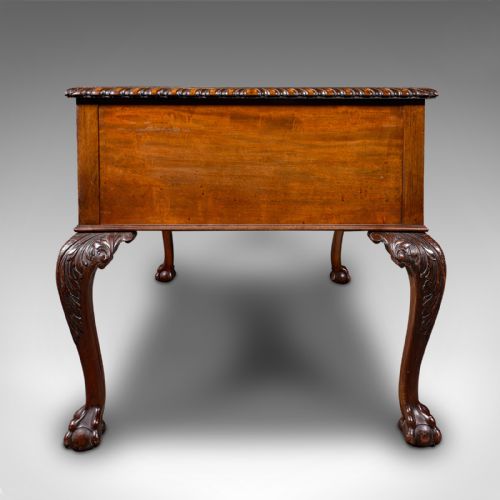 fig 3. An antique Edwardian mahogany writing desk featuring an inset leather top, carved gadrooned edge, five drawers with brass handles, and cabriole legs terminating in ball and claw feet.