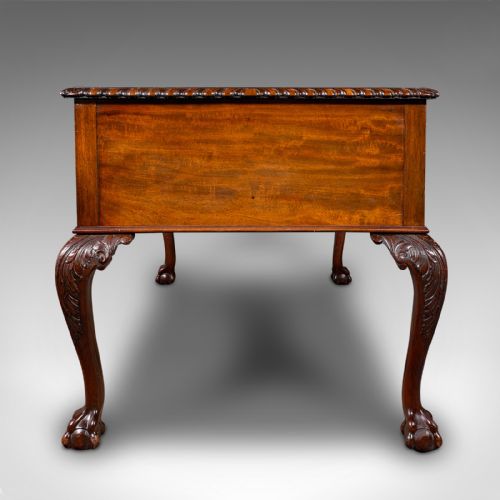 fig 5. An antique Edwardian mahogany writing desk featuring an inset leather top, carved gadrooned edge, five drawers with brass handles, and cabriole legs terminating in ball and claw feet.