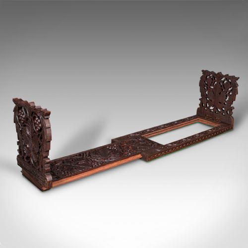 fig 1. An antique dark carved teak extending book slide featuring floral fretwork foldable ends and a carved base.