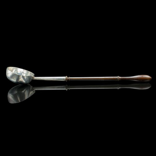 fig 2. An antique Georgian silver toddy ladle featuring a round bowl with an internal partition and a long turned wooden handle.