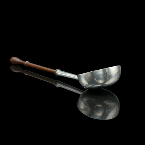 fig 3. An antique Georgian silver toddy ladle featuring a round bowl with an internal partition and a long turned wooden handle.