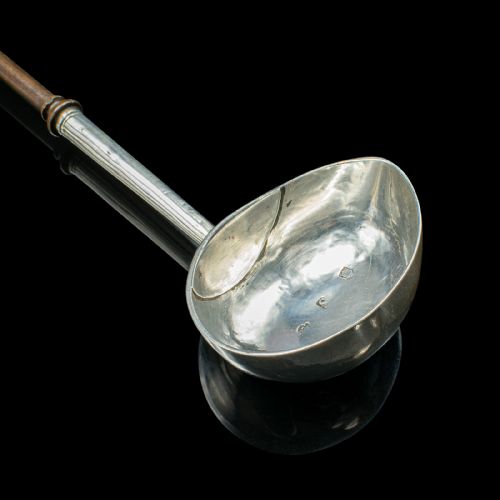fig 4. An antique Georgian silver toddy ladle featuring a round bowl with an internal partition and a long turned wooden handle.