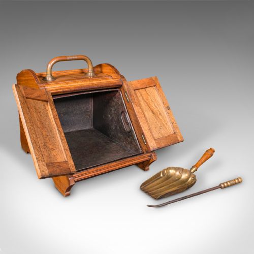 fig 1. A Victorian walnut coal purdonium with panelled slant-front doors, a brass carrying handle, and an attached shovel mounted at the back.