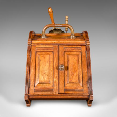 fig 2. A Victorian walnut coal purdonium with panelled slant-front doors, a brass carrying handle, and an attached shovel mounted at the back.