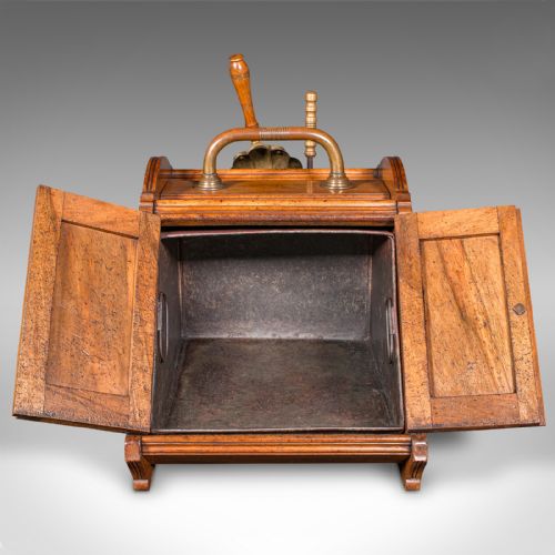 fig 3. A Victorian walnut coal purdonium with panelled slant-front doors, a brass carrying handle, and an attached shovel mounted at the back.