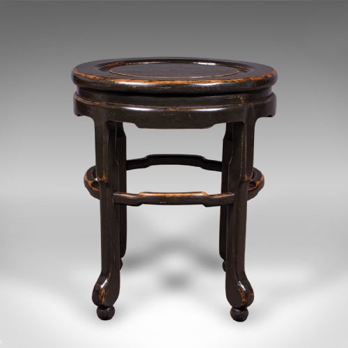 fig 1. An antique Japanese ebonised elm side table featuring an oval top, shaped stretchers, and curved legs.