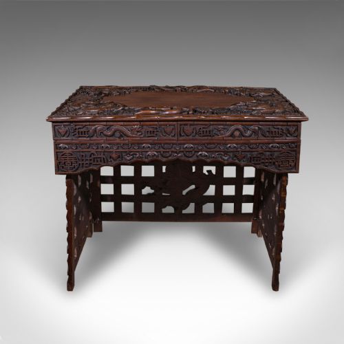 fig 2. A dark brown carved teak folding altar table with deep dragon relief carvings surrounding a flat central top reserve.