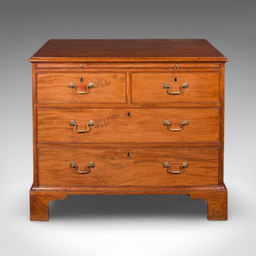 fig 2. An antique Georgian mahogany bachelors chest featuring a brushing slide above two short and two long drawers with brass swan neck handles and bracket feet.