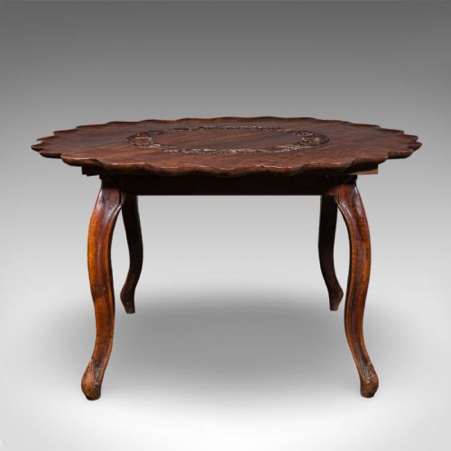 fig 2. An Anglo-Indian carved dark hardwood circular dining table featuring a scalloped piecrust edge, incised top detailing, and cabriole legs.