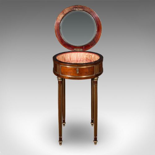 fig 2. An antique French circular bijouterie table crafted from kingwood, featuring fluted legs with brass mounts and an open hinged glazed lid revealing a tufted pink silk interior.