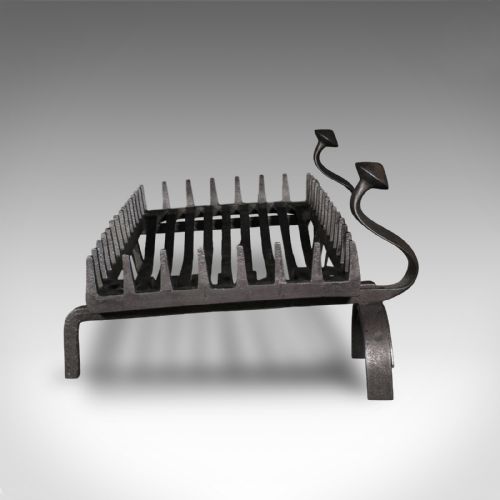 fig 2. An antique dark charcoal iron fire basket featuring a spiked rail and matching end supports with domed finials on arched feet.